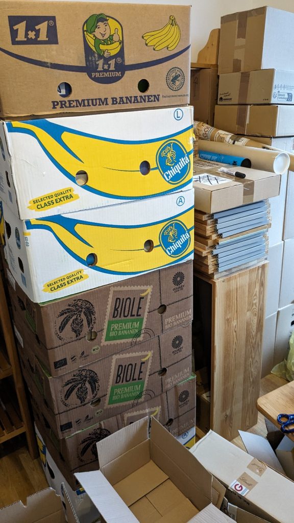 Umzug: gepackte Bananenkisten, Kartons und ein Regal